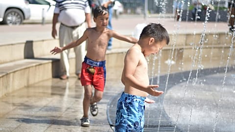Children cooling off in a water fountain in Mongolia.