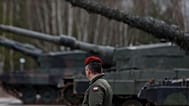 A Polish soldier walks next to the Leopard 2 tanks during a training