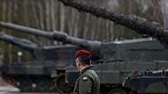 Bei einer Übung geht ein polnischer Soldat neben den Leopard-2-Panzern her.