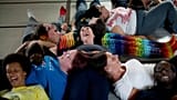 Persone ridono mentre eseguono un esercizio di gruppo durante una lezione di yoga della risata a St. Albans, Inghilterra, il 9 giugno 2013.