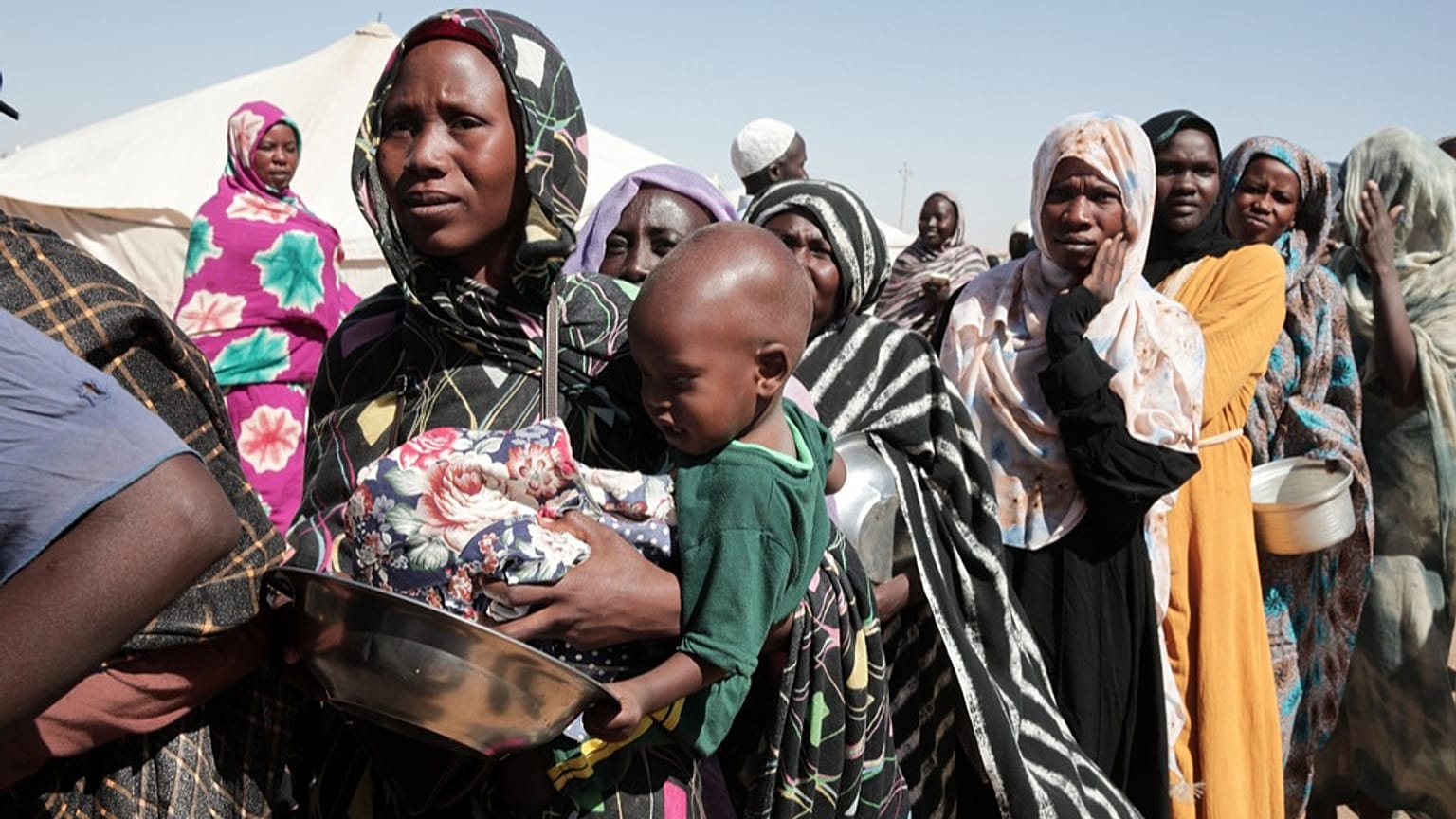 نساء نازحات من مدينة الفاشر يقفن في طابور لتلقي مساعدات غذائية بولاية شمال السودان، في 16 نوفمبر 2025.