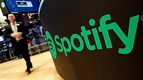 FILE - A trading post sports the Spotify logo on the floor of the New York Stock Exchange.
