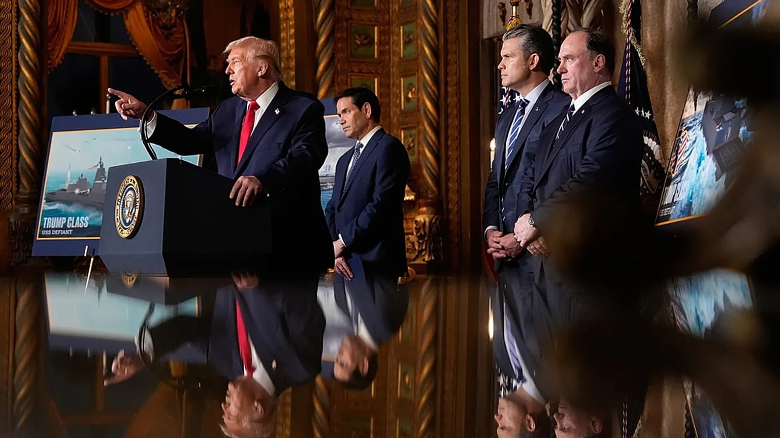 Il Presidente Donald Trump parla con il Segretario di Stato Marco Rubio, il Segretario alla Difesa Pete Hegseth e il Segretario della Marina John Phelan, nel suo club di Mar-a-Lago, il 22 dicembre 2025.