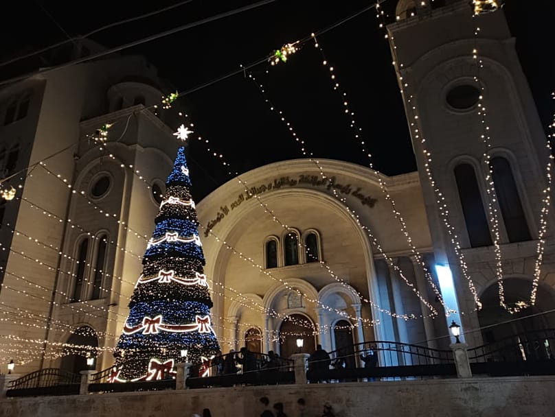 شجرة مزينة أمام كنيسة  رئيسي الملائكة ميخائيل وجبرائيل للروم الأرثوذكس في اللاذقية بحي الأمريكان 2025