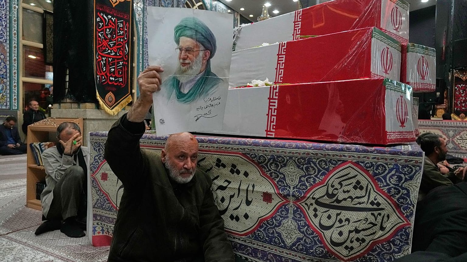 تصویر علی خامنه‌ای در دست یکی از طرفدارانش در مراسم یادبود کشته‌شدگان جنگ ۱۲ روزه با اسرائيل