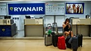 FILE - A Portuguese woman sits at a Ryanair airline check-in desk after her flight to Pisa, Italy, was cancelled on July 25, 2018.