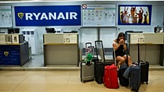 FILE - A Portuguese woman sits at a Ryanair airline check-in desk after her flight to Pisa, Italy, was cancelled on July 25, 2018.