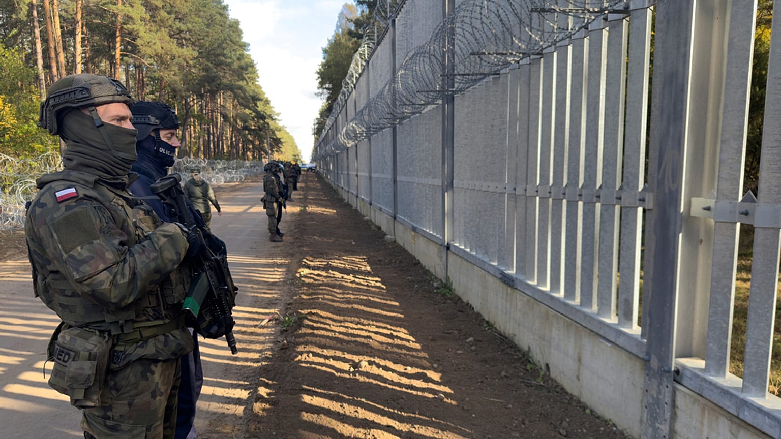 FILE: Servicemen guard at a section of Poland-Belarus border barrier near the Polowce-Pieszczatka, 15 October 2025