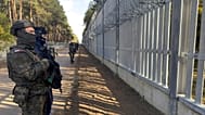 FILE: Servicemen guard at a section of Poland-Belarus border barrier near the Polowce-Pieszczatka, 15 October 2025