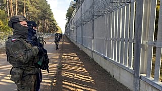 FILE: Servicemen guard at a section of Poland-Belarus border barrier near the Polowce-Pieszczatka, 15 October 2025