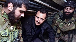 صورة أرشيفية في 31 ديسمبر 2014 تُظهر بشار الأسد يتحدّث إلى قوات سورية خلال زيارة لخطوط المواجهة في حي جوبر شرق دمشق.