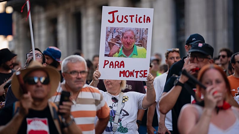 Manifestante carrega um retrato de Montse Aguilar, varredora de ruas que morreu durante uma vaga de calor, com uma mensagem em espanhol que diz: “Justiça para Montse”.