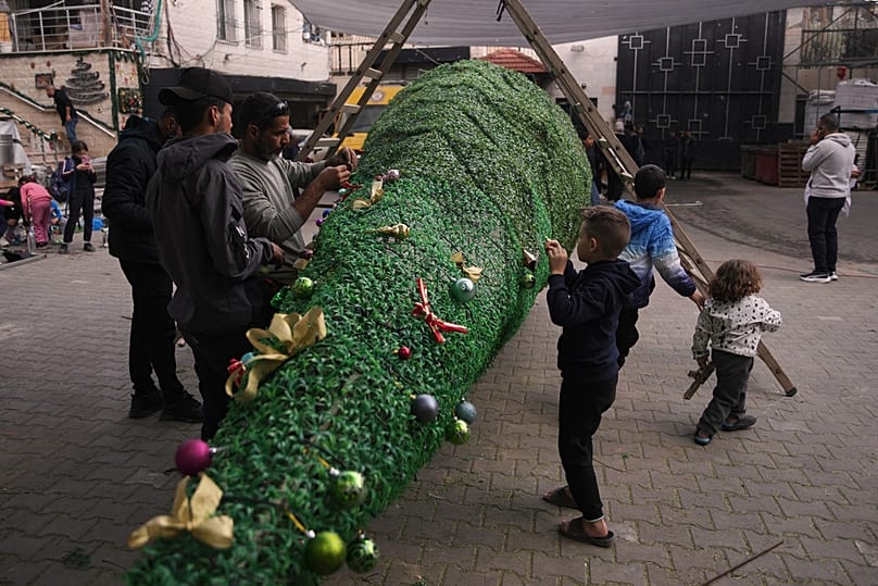 الفلسطينيون يشيدون شجرة عيد الميلاد في كنيسة العائلة المقدسة الكاثوليكية بمدينة غزة، يوم الثلاثاء 23 ديسمبر 2025، استعدادًا للاحتفالات بعيد الميلاد.