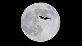 4 Aralık 2025 Perşembe günü Chicago'da süper ay yükselirken bir uçak dolunayın önünden geçiyor.