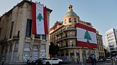 صورة تعبيرية_ عمال يعلقون أعلام لبنان الوطنية الضخمة على المباني احتفالاً بالذكرى الثانية والثمانين لاستقلال لبنان عن فرنسا، في ساحة الشهداء بوسط بيروت