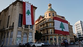 صورة تعبيرية_ عمال يعلقون أعلام لبنان الوطنية الضخمة على المباني احتفالاً بالذكرى الثانية والثمانين لاستقلال لبنان عن فرنسا، في ساحة الشهداء بوسط بيروت