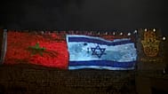 تُعرض أعلام إسرائيل والمغرب على جدران المدينة القديمة في القدس، يوم الأربعاء 23 ديسمبر 2020، إلى جانب كلمة "السلام"
