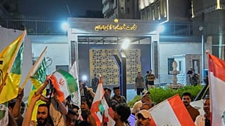 گروهی از طرفداران جمهوری اسلامی در مقابل سفارت ایران، پرچم لبنان و ایران را در دست دارند