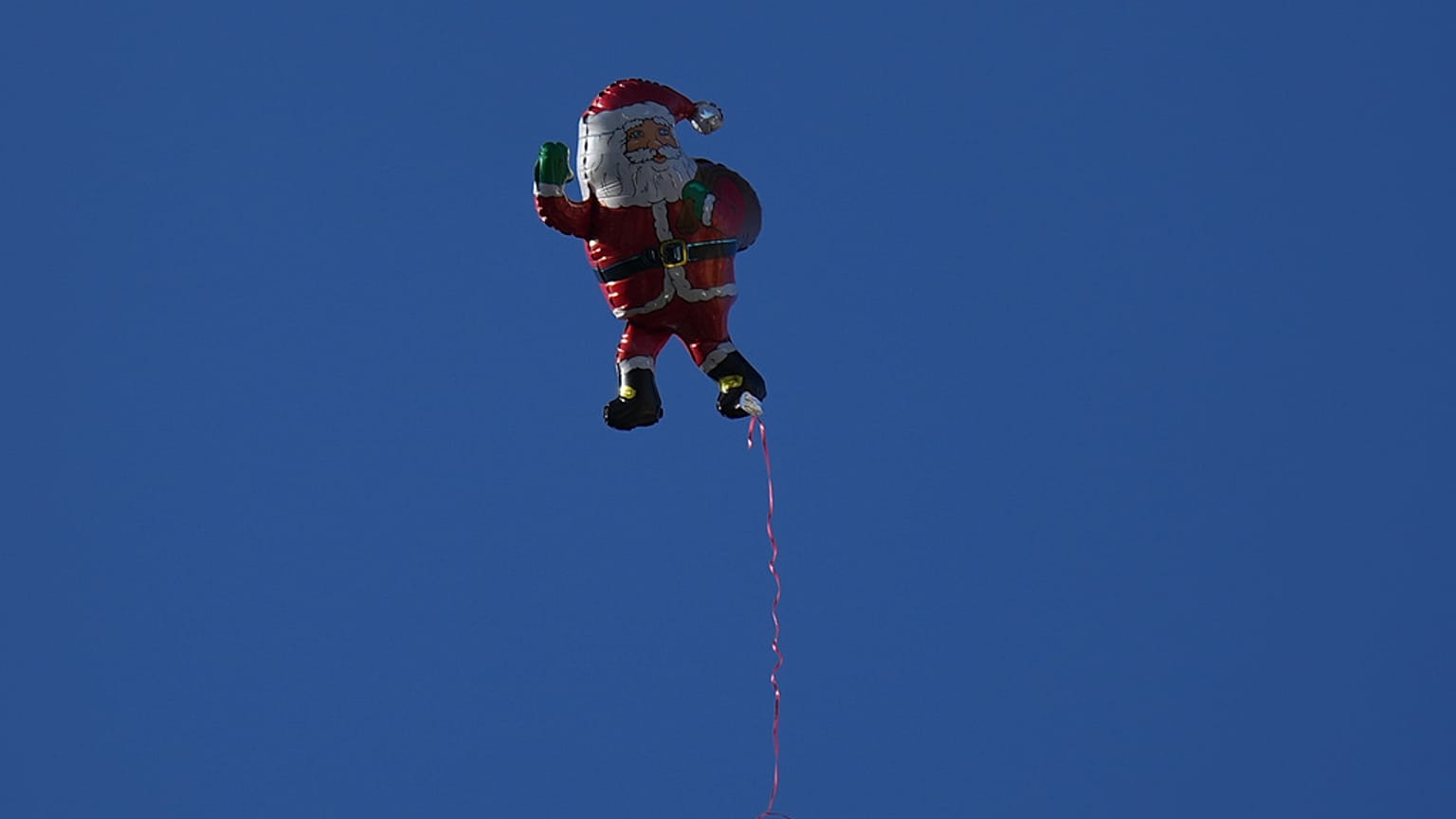 An inflatable Santa Claus drifts through the air as Christians celebrate the 40th annual Christmas parade heading towards the Basilica of the Annunciation in Nazareth, Israel.