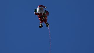 An inflatable Santa Claus drifts through the air as Christians celebrate the 40th annual Christmas parade heading towards the Basilica of the Annunciation in Nazareth, Israel.