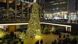 Άνθρωποι ποζάρουν για φωτογραφίες κοντά σε ένα χριστουγεννιάτικο δέντρο στην Έκτη Λεωφόρο, Δευτέρα 22 Δεκεμβρίου 2025, στη Νέα Υόρκη