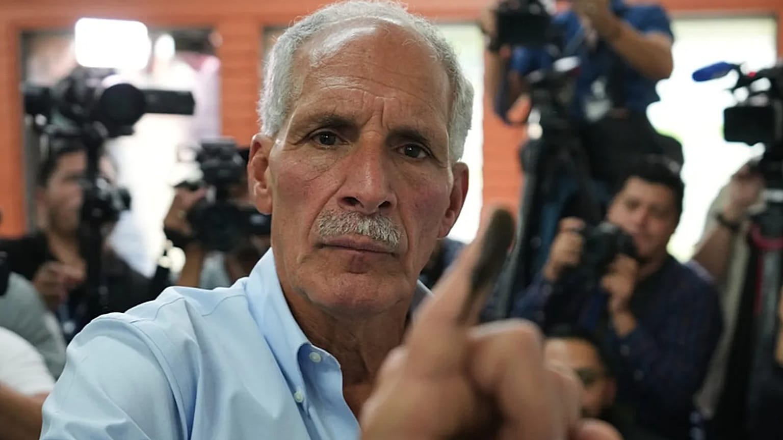 Asfura, candidat à la présidence pour le Parti national, montre son doigt taché d'encre après avoir voté lors des élections générales de 2025 à Tegucigalpa.