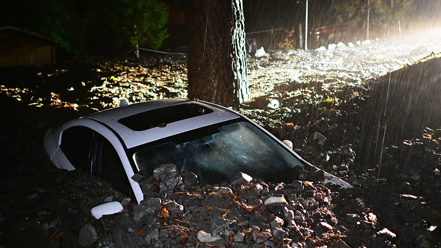 Une voiture est enfouie dans la boue après les inondations du mercredi 24 décembre 2025, à Wrightwood, Californie, États-Unis.