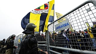 ARŞİV – Silivri’deki şike davasının ilk duruşması öncesinde, Aziz Yıldırım’a destek için alanda bulunan Fenerbahçe taraftarının yanından geçen bir polis. / 14 Şubat 2012 Salı