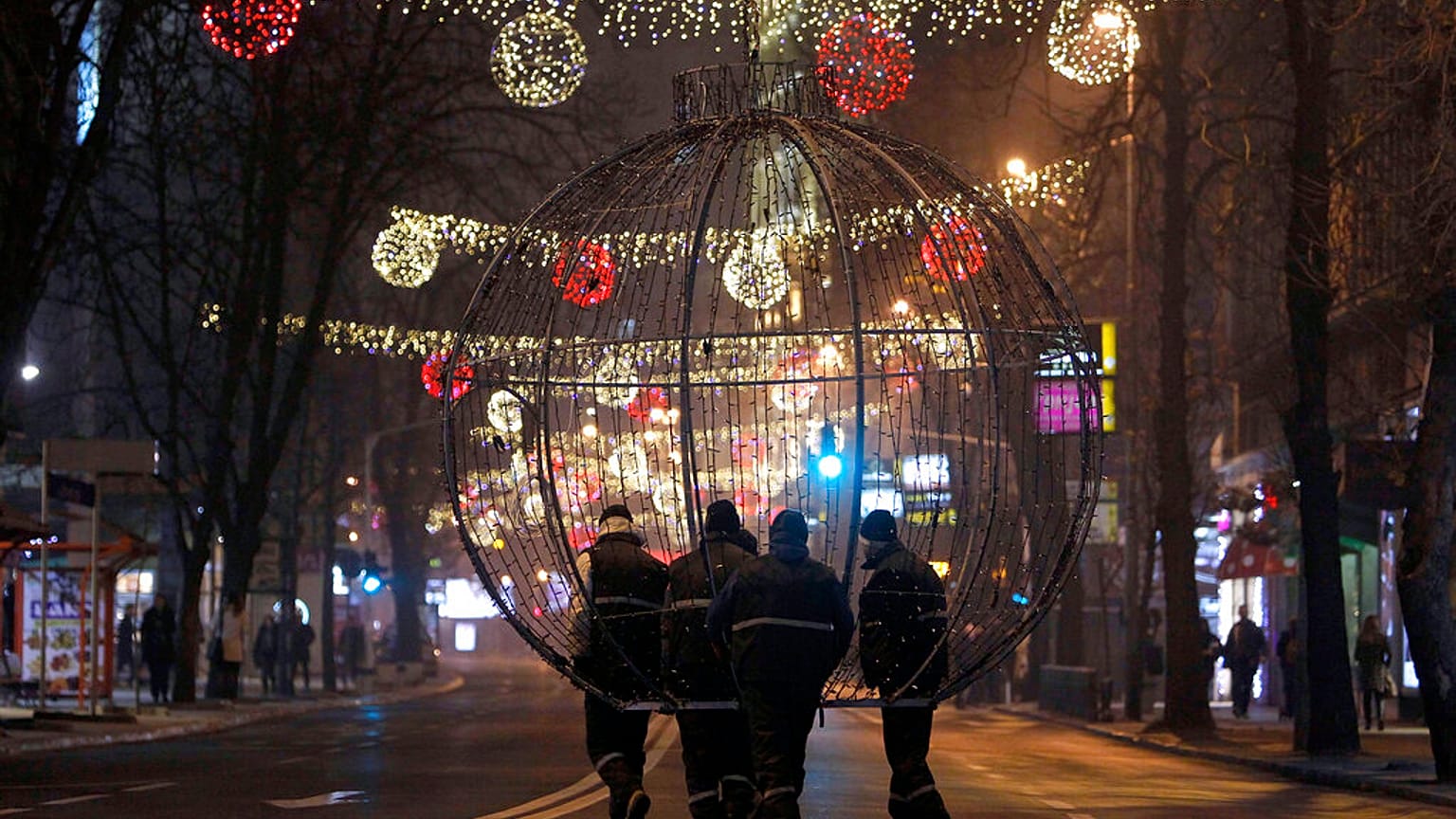 Başkent Üsküp’te işçiler, Noel ve Yeni Yıl süslemeleriyle donatılan bir sokakta dev bir Noel dekorasyonunu taşıyor, 21 Aralık 2025.