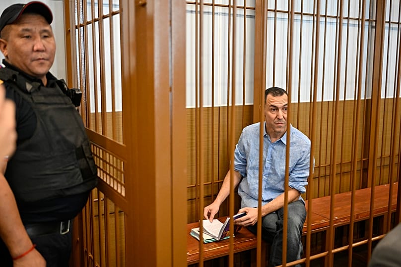  يجلس المواطن الفرنسي لوران فيناتييه (على اليمين) في قفص داخل قاعة محكمة في محكمة زاموسكفوريتسكي الجزئية في موسكو، روسيا، يوم الاثنين 16 سبتمبر/أيلول 2024.