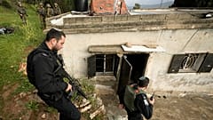 زار ضباط شرطة إسرائيليون منزلاً فلسطينياً محترقاً في قرية سنجيل قرب مدينة رام الله بالضفة الغربية، يوم الأحد 26 مارس/آذار 2023.
