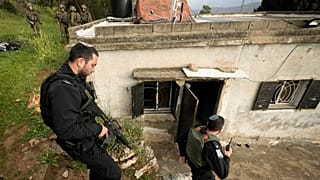 زار ضباط شرطة إسرائيليون منزلاً فلسطينياً محترقاً في قرية سنجيل قرب مدينة رام الله بالضفة الغربية، يوم الأحد 26 مارس/آذار 2023.