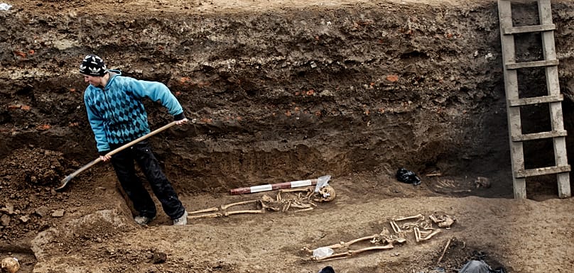 Roumanie : un ouvrier creuse à côté de squelettes humains estimés à environ 400 ans. Photo 2010