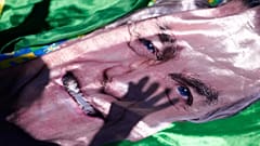 DATEI: Der Schatten eines Anhängers des ehemaligen Präsidenten Jair Bolsonaro wird auf ein Bild von ihm geworfen, in Brasilia, 24. Dezember 2025