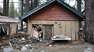 Davey Schneider, 25 Aralık 2025'te ABD'nin Kaliforniya eyaletindeki Wrightwood'da fırtınadan zarar gören evinden eşyalarını kurtarıyor.