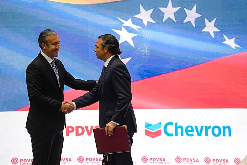 FILE -Venezuelan Petroleum Minister Tareck El Aissami shakes hands with Chevron President in Venezuela, Javier La Rosa, during an agreement signing ceremony in Caracas.