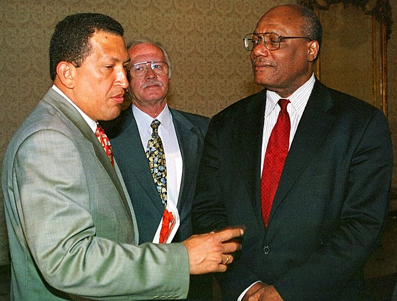 FILE - Chavez, left with Under-Secretary of the Organization of American States Christopher Thomas in the presidential house La Casona in Caracas, Monday, July 26, 1999. 