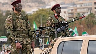 FILE: New Syrian army soldiers stand next to an armoured drone in Damascus, 8 December 2025