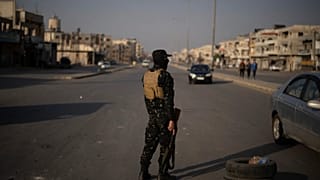 Humus'taki bir kontrol noktasında Suriye güvenlik güçlerine mensup bir kişi, 2024