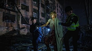 Archív fotó: rendőrök segítenek egy sebesült nőnek egy orosz légicsapás után Kijevben