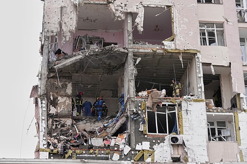 Rescuers work on the scene of a building damaged by a Russian attack in Kyiv, Ukraine, Saturday, Dec. 27, 2025.