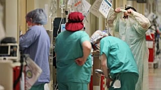 ممرضة ترتدي طبقة إضافية من معدات الحماية الشخصية قبل دخول غرفة مريض مصاب بكوفيد-19 في مركز نورث ميسيسيبي الطبي في توبيلو، ميسيسيبي