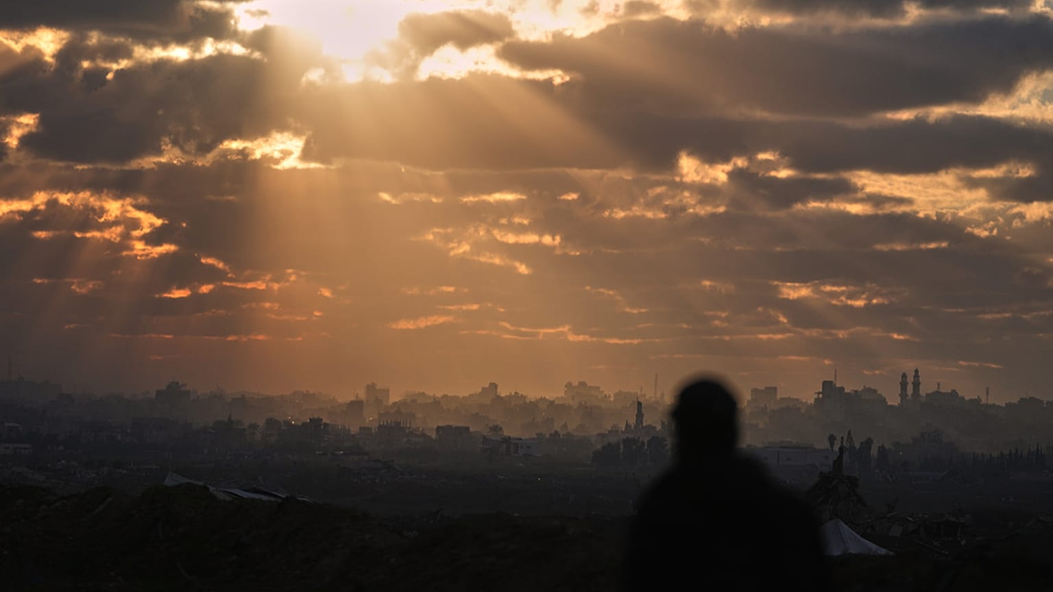 ينظر فلسطيني إلى منطقة من المباني المدمرة خلال العمليات الجوية والبرية الإسرائيلية عند غروب الشمس في شمال النصيرات، وسط قطاع غزة، يوم الجمعة 19 ديسمبر/كانون الأول 2025.