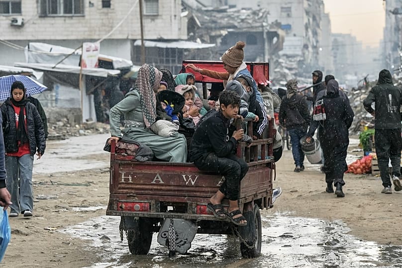 A Palestinian family rides on a cart amid the rain in Gaza City, Monday, Dec. 15, 2025.