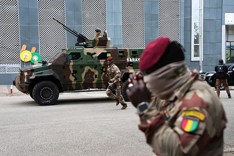 FILE - Guinean soldiers secure the area outside a polling station before Gen. Mamadi Doumbouya arrives to vote in the constitutional referendum, Conakry, Guinea, Sep. 21, 2025