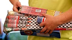 Auf diesem Archivfoto vom 16. Juni 2017 hält Julian Gibson aus Dallas Center, Iowa, Feuerwerkskörper in den Händen, bevor er sie in einem Zelt der Iowa Fireworks Company in Ad
