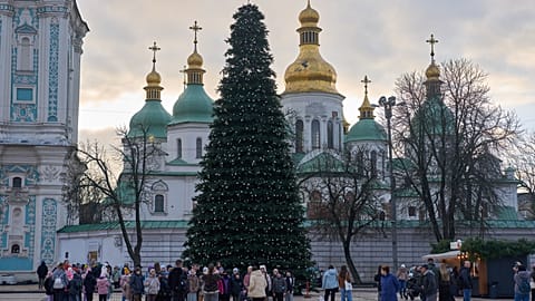 People walk around the Christmas tree in front of St. Sophia Monastery in central Kyiv, Ukraine, Wednesday, Dec. 10, 2025. 