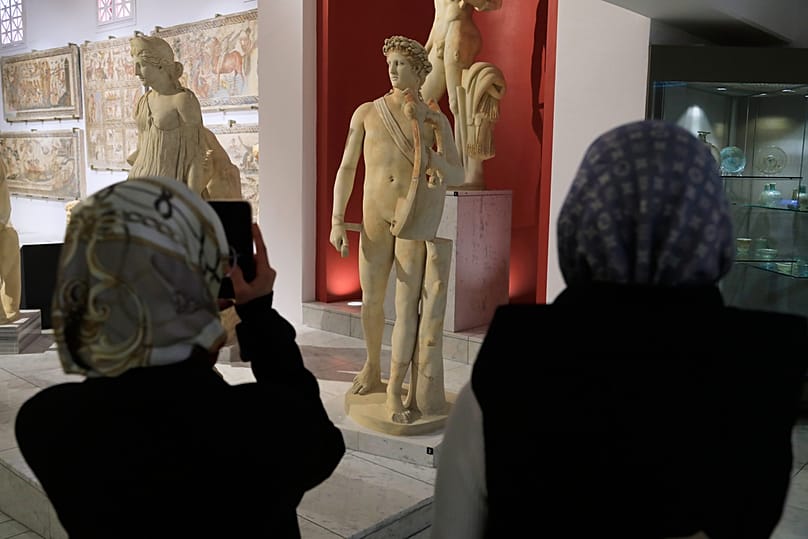 Visitors view Greek artifacts displayed at the National Museum in Tripoli, Libya, Wednesday, Dec. 17, 2025.