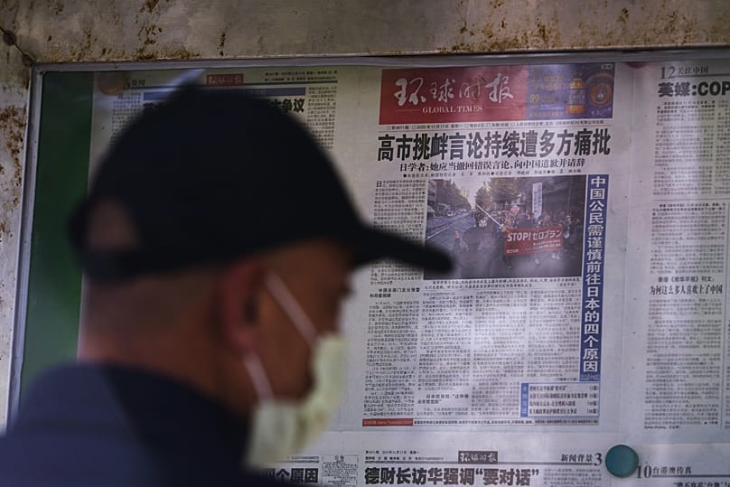 A man reads local newspapers reporting on Japanese Prime Minister Sanae Takaichi's recent remarks on Taiwan at a newsstand in Beijing, 17 November, 2025