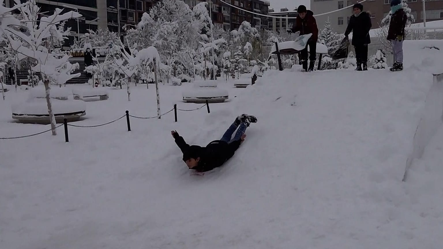 A child takes advantage of heavy snowfall to slide on their belly in Van province, Turkey, Dec. 28, 2025.